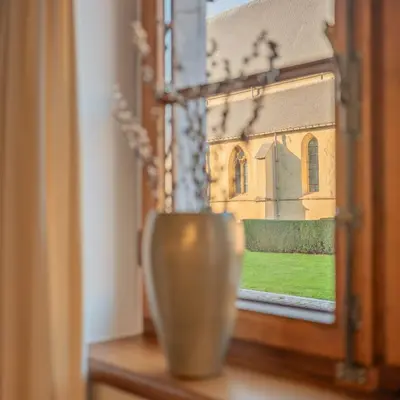 a vase sitting on a window sill next to a church at Vakantiewoning Begijnhof 54 in Sint-Truiden