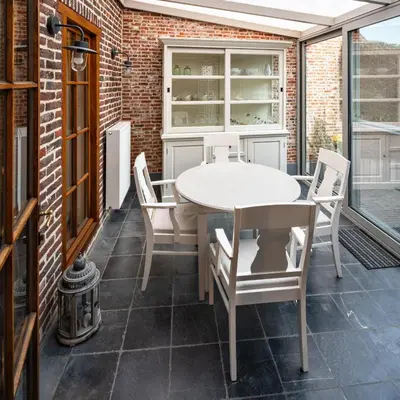 a patio with a white table and chairs at Vakantiewoning Begijnhof 54 in Sint-Truiden