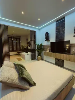 a bedroom with a large bed and a flat screen tv at Charnel - Bora Bora in Liège