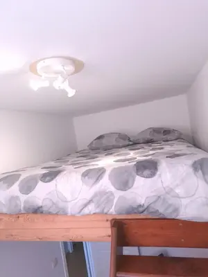 a bed in a room with a ceiling at L'Horizon Saint-Lambert in Liège