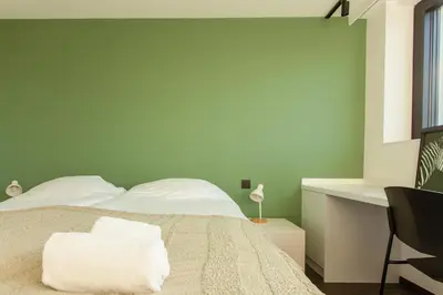 a bedroom with a bed with a green wall at 8P 4B Luxury Villa Close to Maastricht in Lanaken