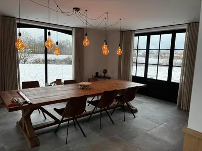 a dining room with a wooden table and chairs at Hidden Secret of Nature in Neeroeteren
