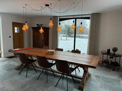a dining room with a wooden table and chairs at Hidden Secret of Nature in Neeroeteren