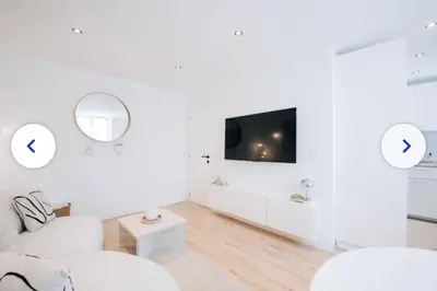 a white living room with white furniture and a tv at Chic et cosy idéal pour un séjour à Liège in Liège