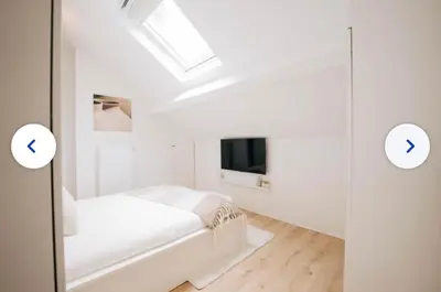 a white bedroom with a bed and a skylight at Chic et cosy idéal pour un séjour à Liège in Liège