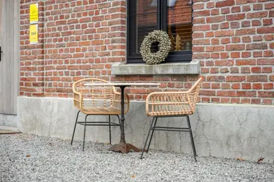 a table and two chairs in front of a brick building at Huys van Haeghe in Zoutleeuw