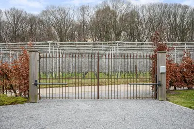 a gate in front of a white fence at Huys van Haeghe in Zoutleeuw