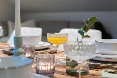 a wooden table with glasses of orange juice on it at Huys van Haeghe in Zoutleeuw