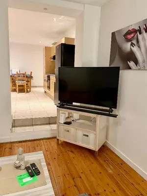 a living room with a flat screen tv on a stand at Le Clémenty in Dison