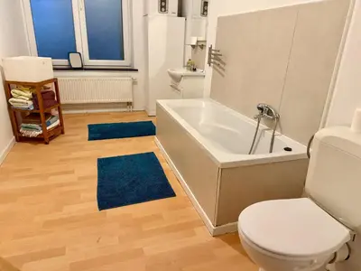 a bathroom with a tub and a toilet and a sink at Le Clémenty in Dison