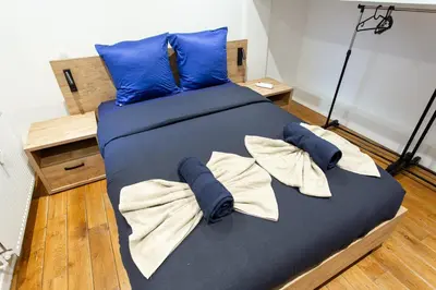 a large bed with blue sheets and towels on it at Le Nid in Liège