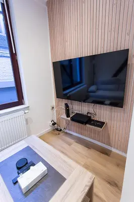 a living room with a large flat screen tv on a wall at Le Nid in Liège