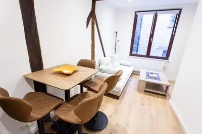 a living room with a table and chairs and a couch at Le Nid in Liège