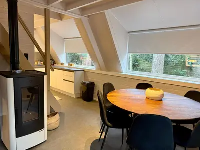 a kitchen and dining room with a table and a stove at Boshuisje Rekem - Arden in Lanaken