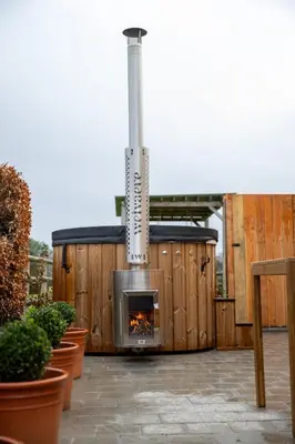 a fireplace on a wooden building with plants at Le Marzelheide 3 in Lontzen