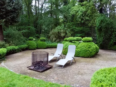 two chairs and a fire pit in a garden at Fishing Chalet, Opglabbeek in Oudsbergen