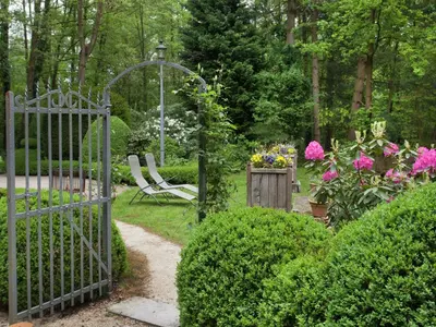 a garden with a gate and some bushes and flowers at Fishing Chalet, Opglabbeek in Oudsbergen
