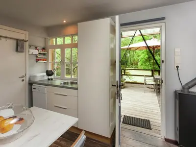 a kitchen with a sliding door leading to a deck at Fishing Chalet, Opglabbeek in Oudsbergen