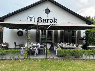 a restaurant with tables and umbrellas in front of a building at maison Clavita in Genk