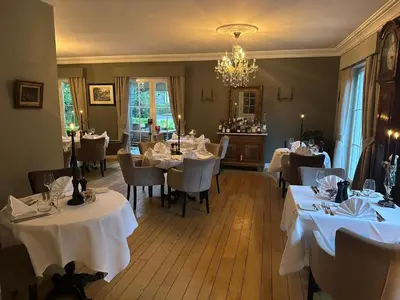 a restaurant with white tables and chairs and a chandelier at maison Clavita in Genk
