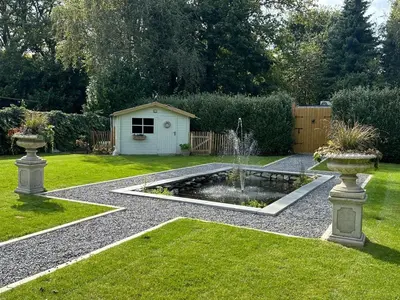 a garden with a fountain in the middle of a yard at maison Clavita in Genk