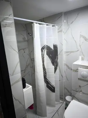 a bathroom with a shower curtain and a toilet at Modern lux studio B in Beringen