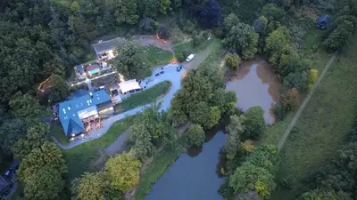 an aerial view of a house next to a river at Homestorys Nature Resort - Lakeview Pavilion in Eupen