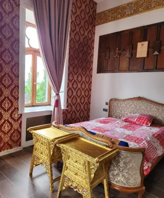 a bedroom with a bed with a table and a window at Kasteel Rosmeulen in Mall
