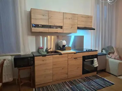 a kitchen with wooden cabinets and a sink and a stove at La Vie en Rose in Ensival