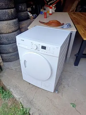 a white washing machine sitting on a table at La Vie en Rose in Ensival