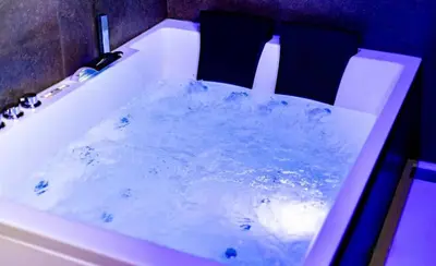 a bath tub filled with water in a bathroom at Your wellness break in Dalhem
