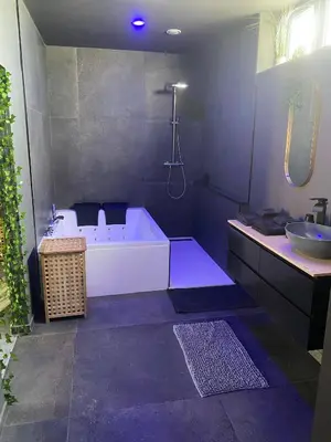 a bathroom with a bath tub and a sink at Your wellness break in Dalhem