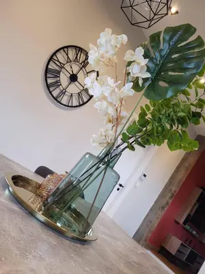 a vase with white flowers in it on a table at Charming 2-Bedroom House Rental in Dalhem, Belgium in Dalhem