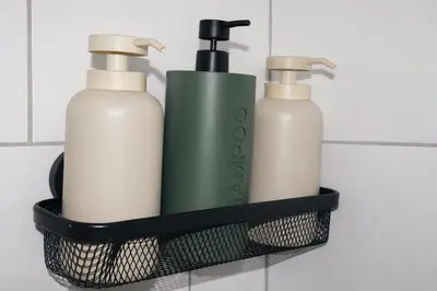 two bottles of soap in a black holder in a bathroom at Hoeve Verdre - De Knechtenwoning in Heers