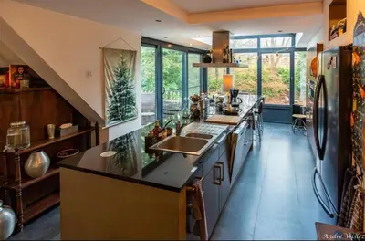 a kitchen with two sinks and a counter with windows at Villa des Bois Sauvages in Liège