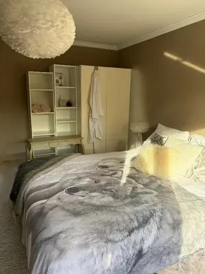 a bedroom with a large bed with a painting on it at Villa des Bois Sauvages in Liège