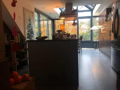 a kitchen with a counter in a room with windows at Villa des Bois Sauvages in Liège