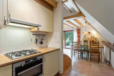 a kitchen with a stove top oven next to a dining room at Riet&Rust in Lanaken