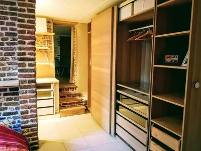 a walk in closet with wooden shelving at Au coeur de l'Ardenne - Peaceful loft in Baelen