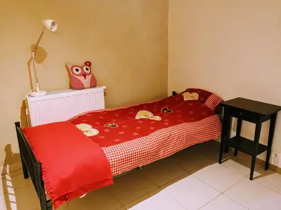 a childs bedroom with a red blanket with an owl on it at Au coeur de l'Ardenne - Peaceful loft in Baelen