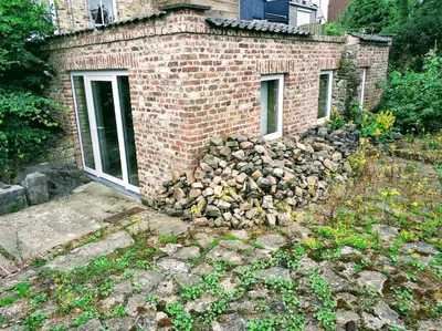 a pile of logs on the side of a brick building at Au coeur de l'Ardenne - Peaceful loft in Baelen