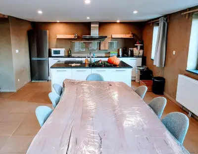a kitchen with a long table and chairs in it at Au coeur de l'Ardenne - Peaceful loft in Baelen