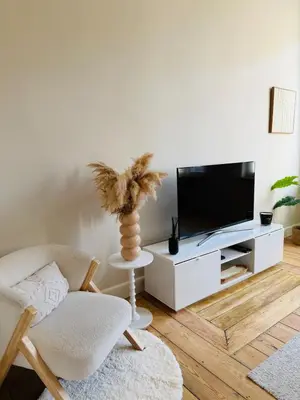a living room with a tv and a chair at Appartement Premium à Liège in Liège
