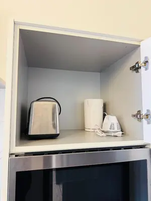 a kitchen with two toasters and a toaster on a shelf at Appartement Premium à Liège in Liège