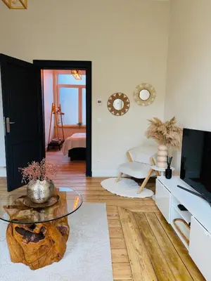 a living room with a glass table and a television at Appartement Premium à Liège in Liège