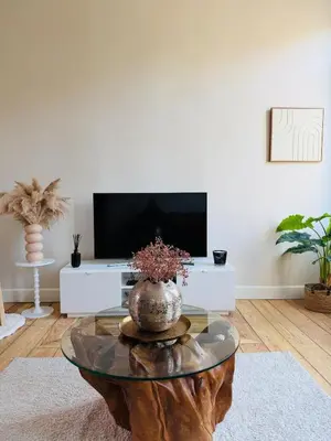 a living room with a table and a tv at Appartement Premium à Liège in Liège