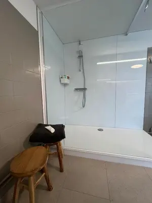 a bathroom with a shower and a stool and a glass shower stall at House with garden for 4 people in Verviers