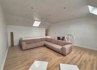 a large living room with a couch and wooden floors at Home cinema in Liège
