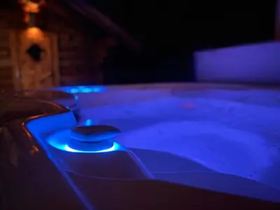 a hot tub with blue lights in a dark room at Wellness L'eau Belle in Beringen