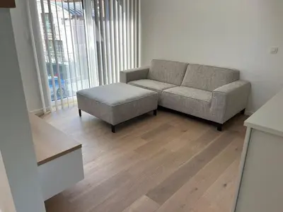 a living room with a couch and a ottoman at Atelier Cosy in Pepinster